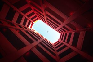 low angle photography of building showing airplane on skies