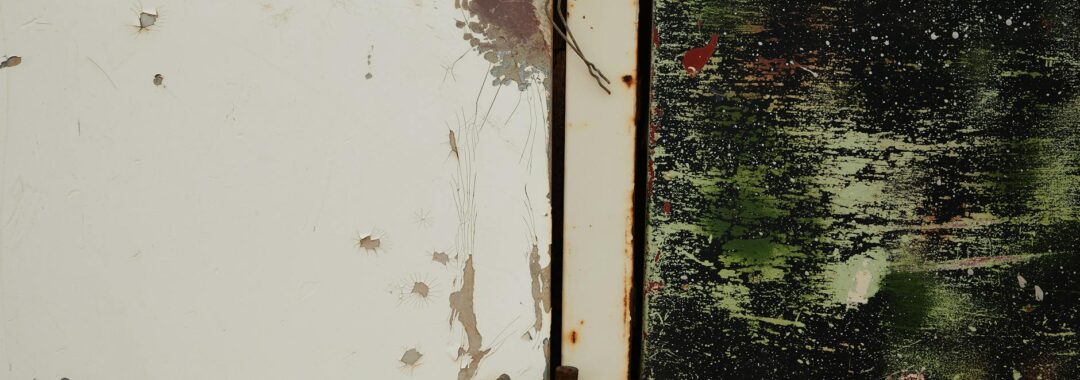 old shabby metal door with rusty hinge near green wall