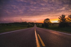 photo of empty road in between grass field during golden hour